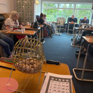 Seniors enjoying a quiet bingo activity together in a bright communal lounge.