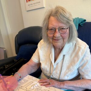 Resident sitting comfortably while coloring a picture during a creative activity session.