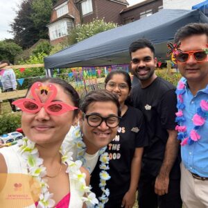 Care home team members enjoying a colourful outdoor summer celebration.