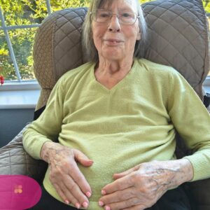 Resident smiling comfortably after a relaxing manicure treatment.