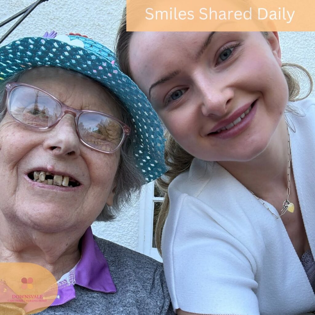 Resident and caregiver sharing a cheerful outdoor selfie together.