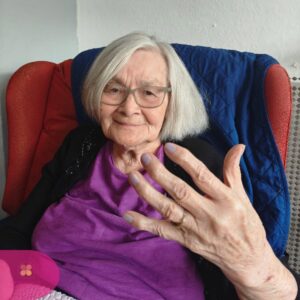 Resident showing off beautifully painted lavender nails with a smile.