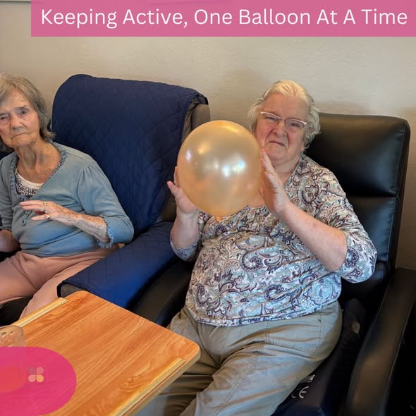 Resident smiling while taking part in a fun balloon exercise activity.