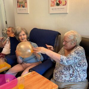 Elderly residents passing a balloon and staying active indoors.