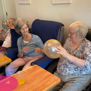 Residents enjoying a balloon game together during a group activity.