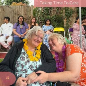 Two residents share a joyful moment together at an outdoor celebration.