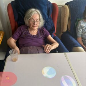 Resident watching colourful light projections on an interactive table.