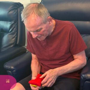 Resident participating in a bean bag activity to improve hand coordination.
