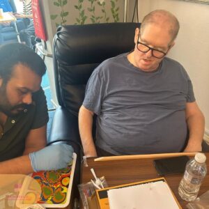 Resident taking part in a colourful arts and crafts activity with staff support.
