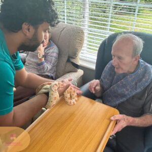 Staff member engaging a resident with a gentle hands-on sensory activity.