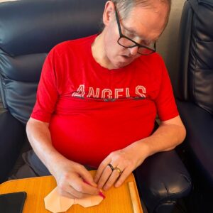 Resident enjoying a paper-folding activity with focus and creativity.