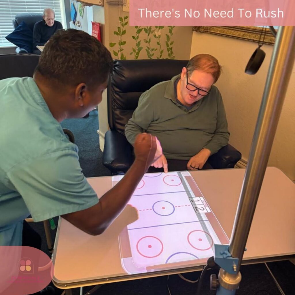 A care team member and resident enjoy an interactive tabletop game that encourages engagement and fun.