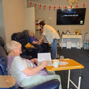 Performer encouraging a resident to sing along during an engaging music activity.