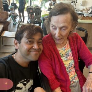 Resident and companion sharing a happy moment at the café.
