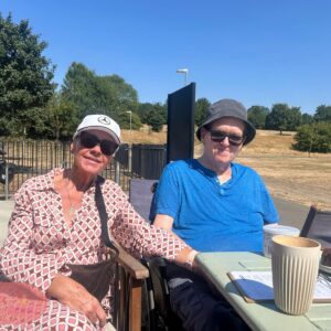 Residents enjoying refreshments at an outdoor café on a sunny day.