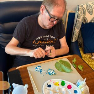 Resident creating leaf prints with colourful paint.