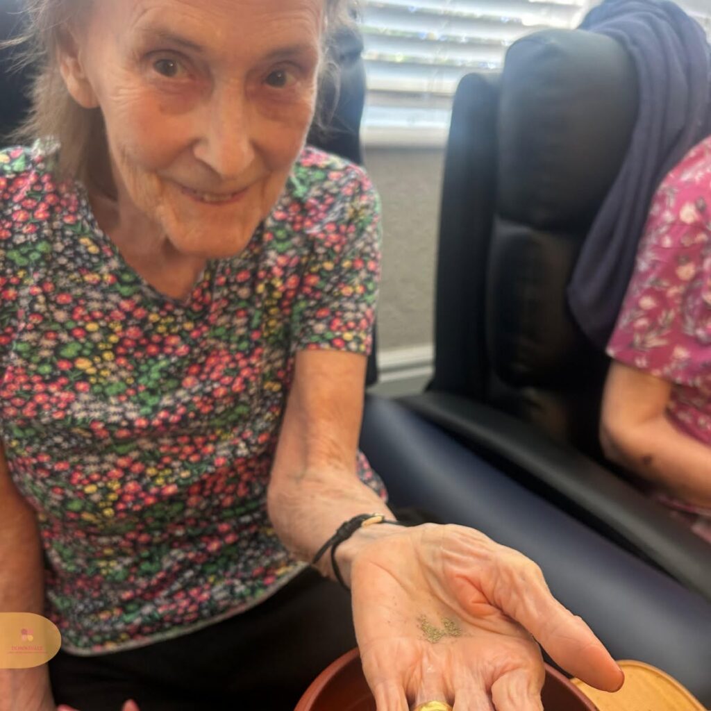 Resident holding seeds during gardening activity.