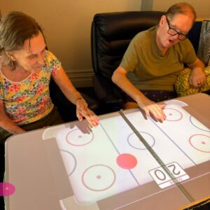 Two residents enjoy a hands-on digital game together.