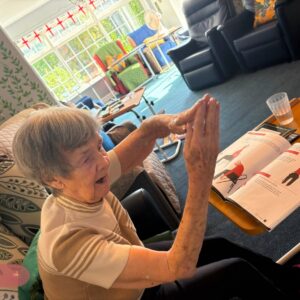 Elderly woman practising a seated yoga pose.