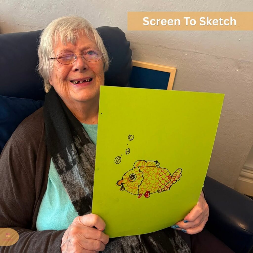 Smiling older woman holding up her colourful sketch.