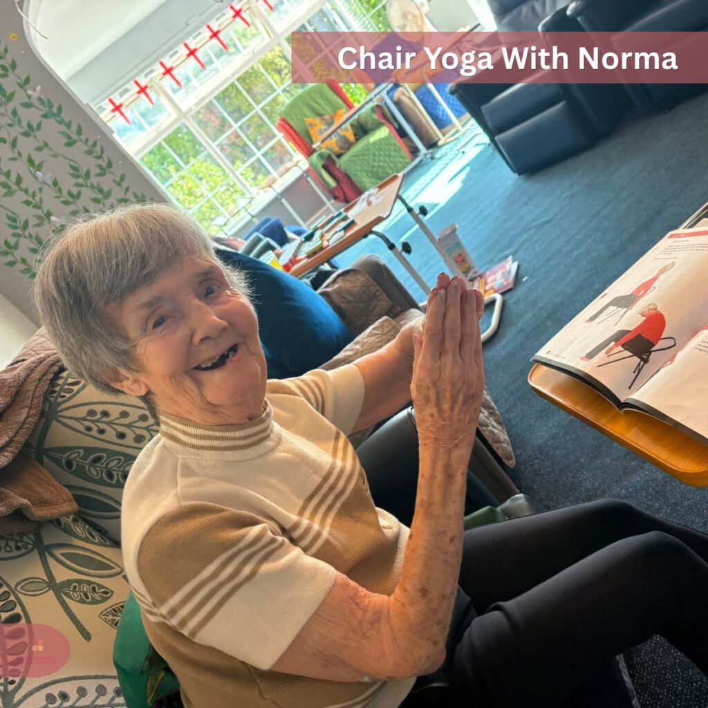 Smiling elderly woman enjoying chair yoga.